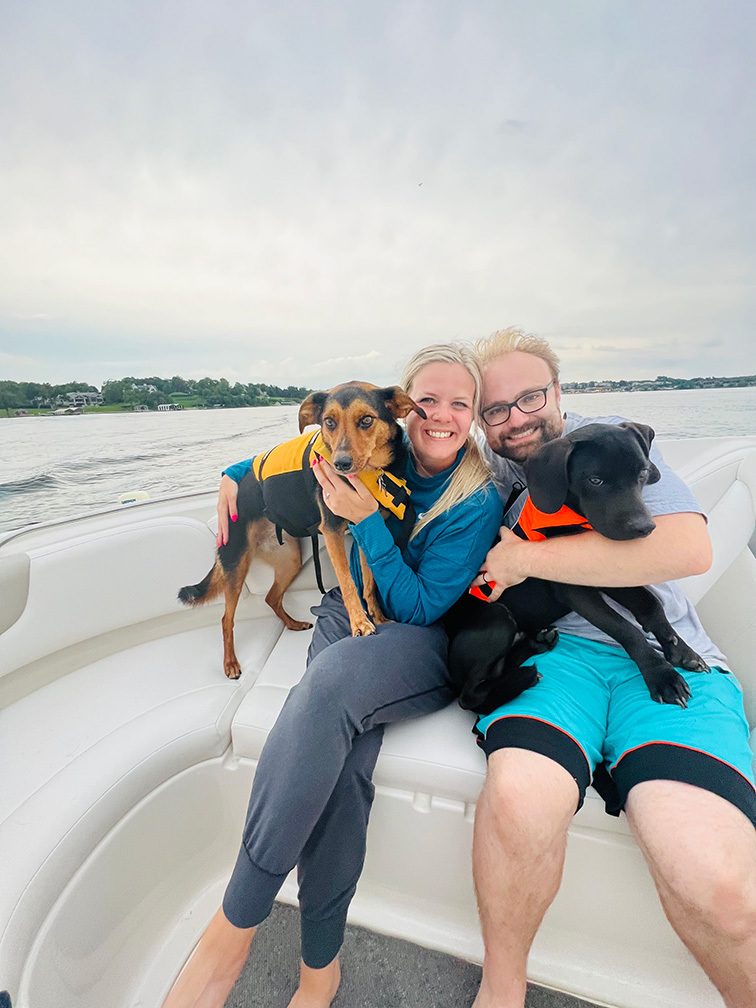 Katie with husband, Andy, and dogs, Millie and Ford, on boat