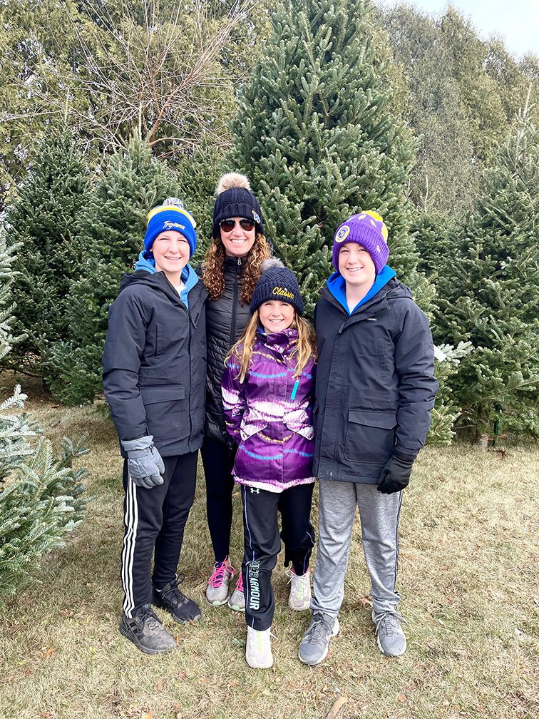 Emily Dolan with her children in front of Christmas Trees